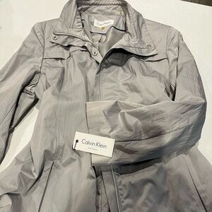 New with tags, Silver Calvin Klein stylish water repellent raincoat size XL.